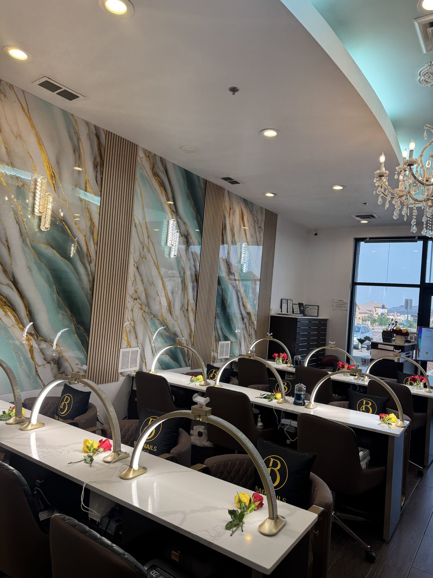 Row of luxury pedicure chairs beneath a crystal chandelier